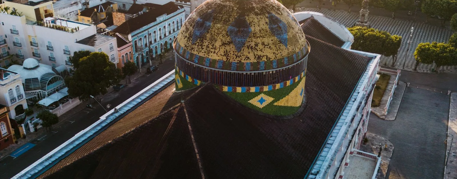Aerial view of the pink Teatro Amazonas opera house in the historic center of Manaus at dusk.