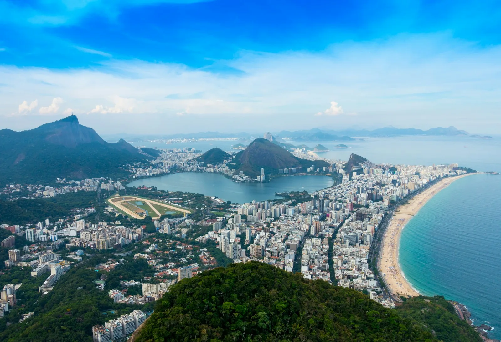 Aerial view of Rio de Janeiro showing Sugarloaf Mountain, Guanabara Bay, and the beaches of Zona Sul at golden hour.