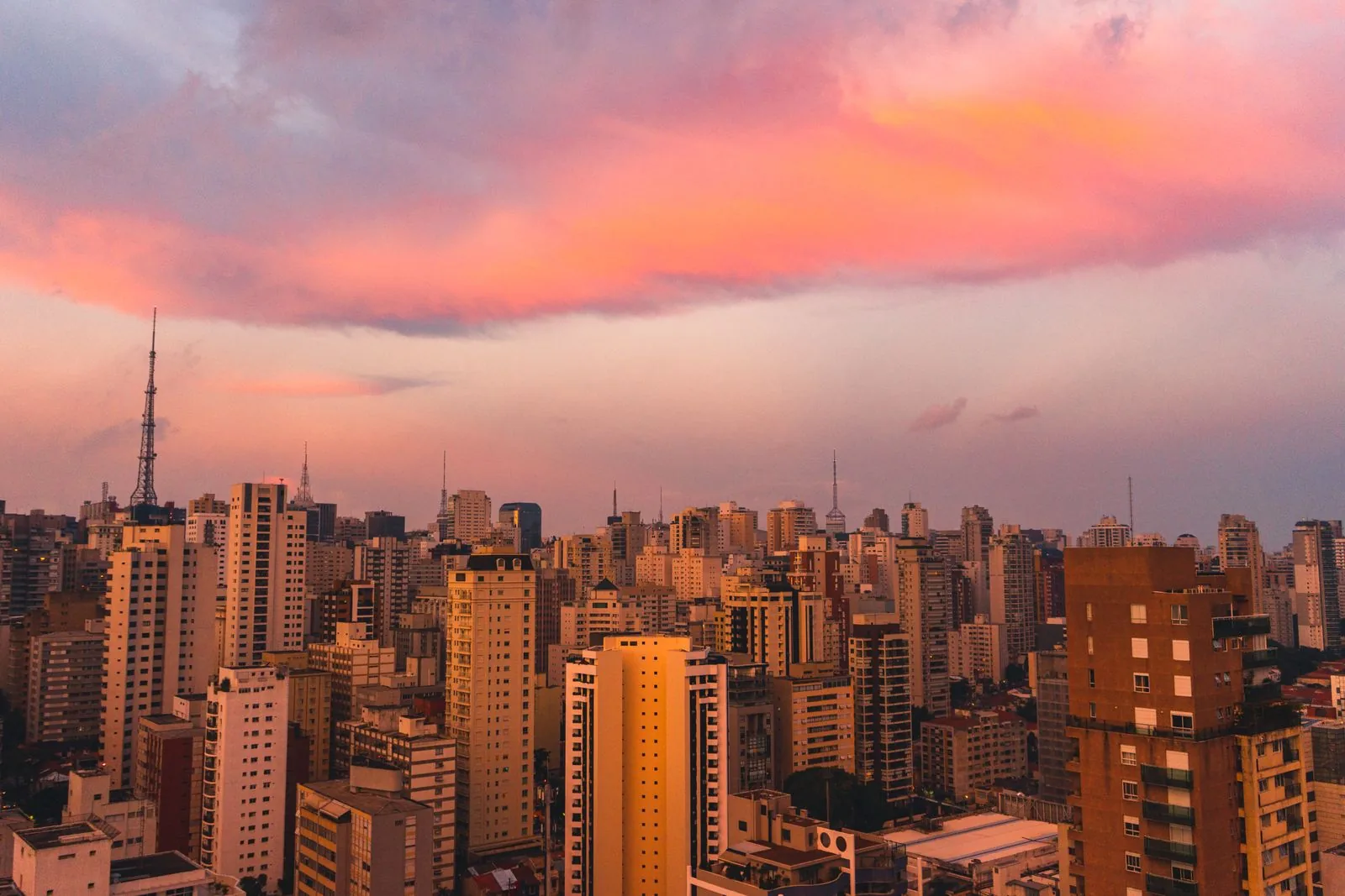Vista aérea de Río de Janeiro al atardecer, con montañas y horizonte urbano.