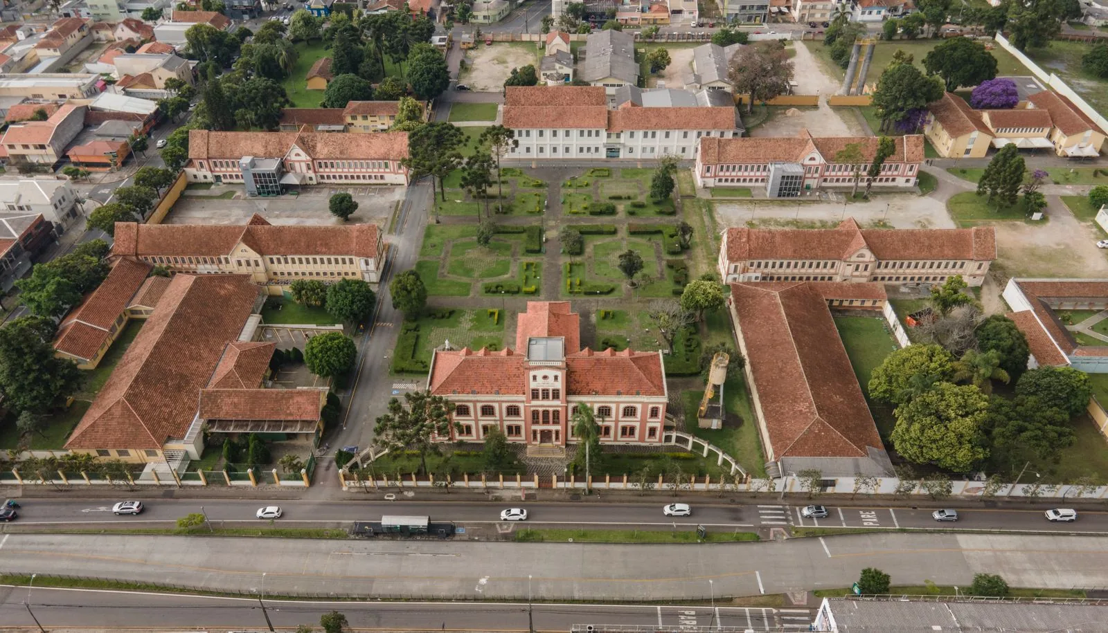 Aerial view of a walkable southern Brazilian city with tree-lined streets, compact blocks, and orderly traffic.
