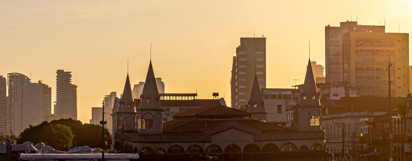 Boats along the Belém waterfront at dusk with historic city buildings and the river in view.