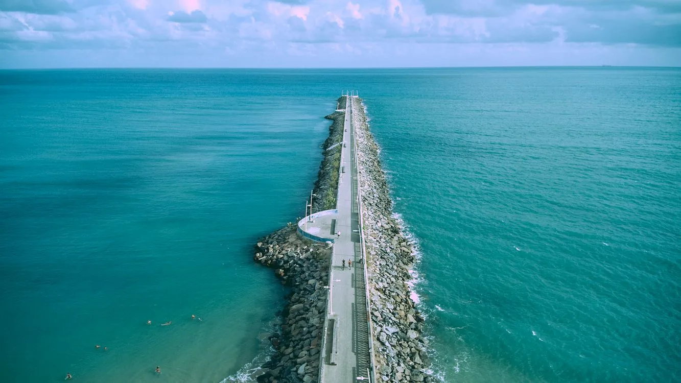 Bright Fortaleza shoreline with blue water and sandy beach, used to reinforce beach-safety and awareness guidance.