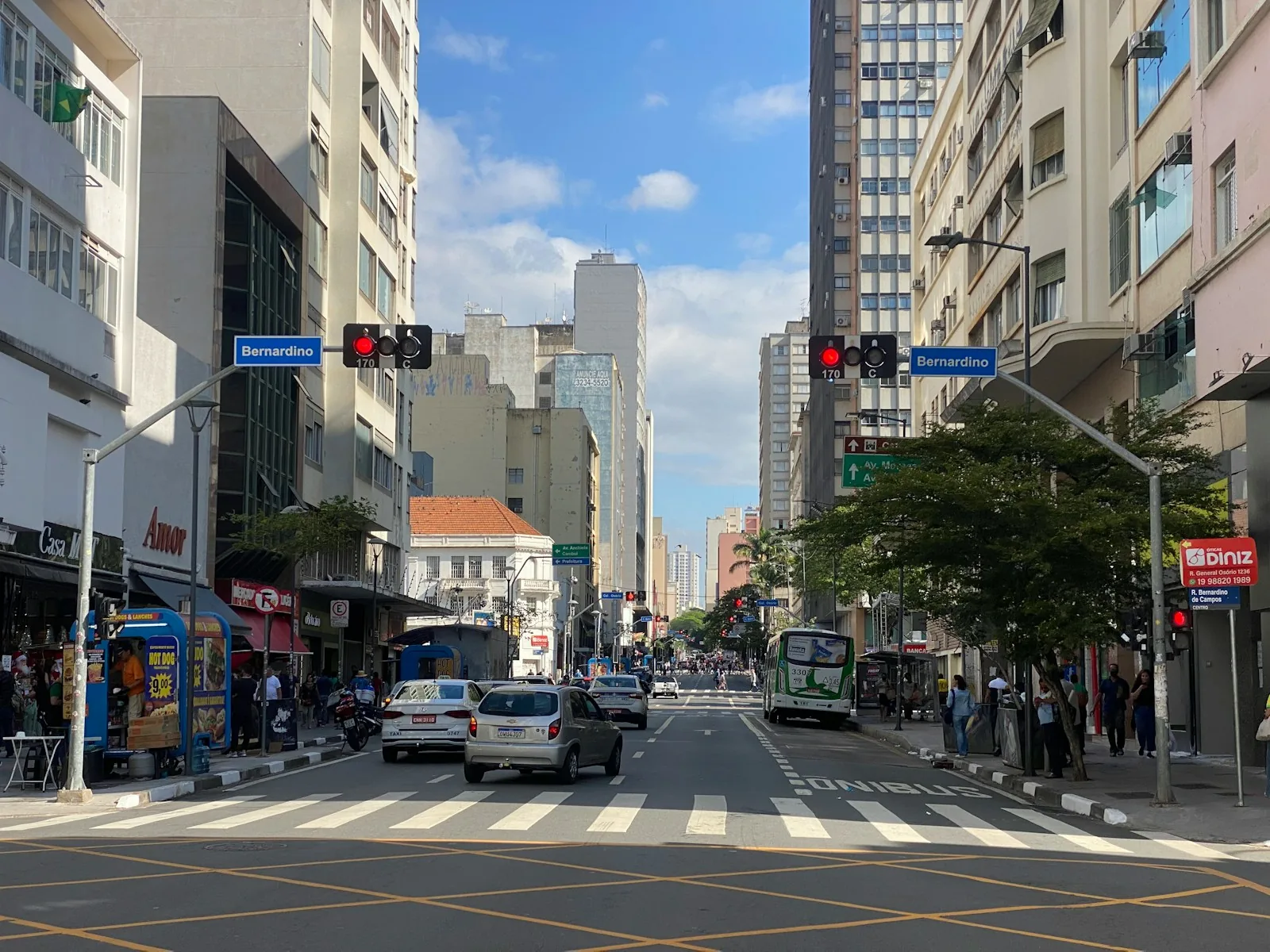 Street-level view of Campinas with cars and foot traffic, reinforcing the recommendation to stay in the busy central neighborhoods.
