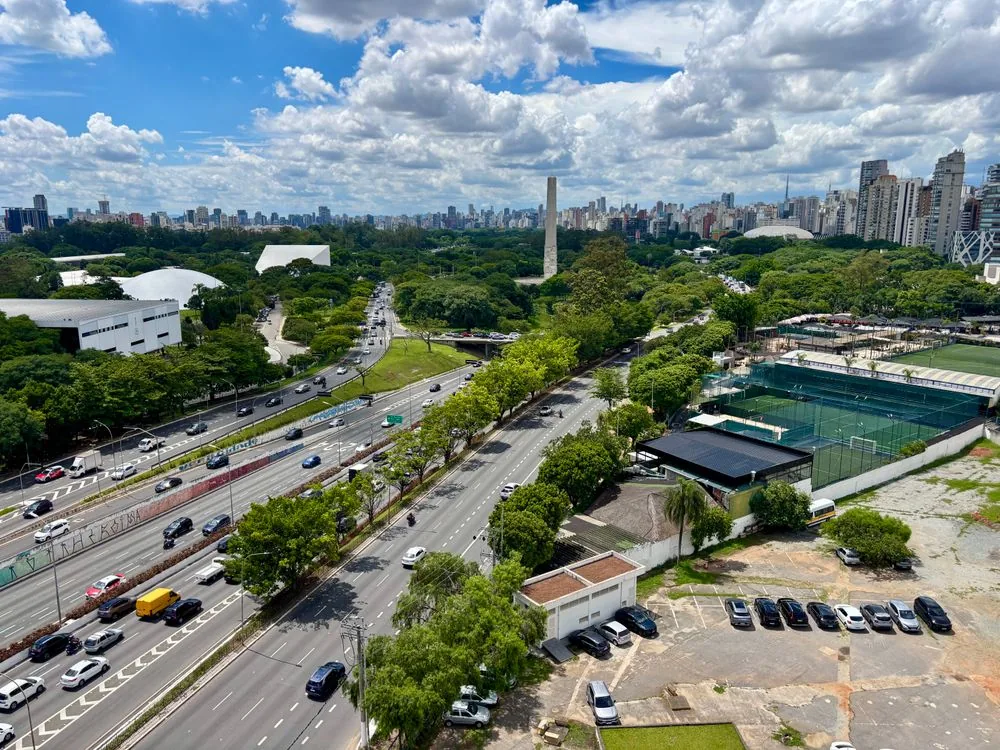 Colorful daytime city scene with bright movement, used to compare transport options between São Paulo and Rio.