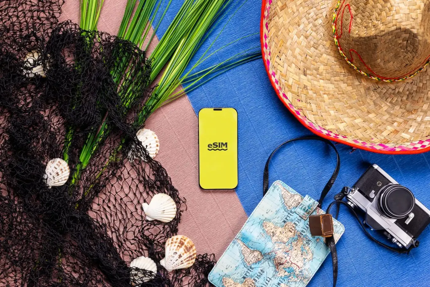 A smartphone showing an eSIM alongside a hat, camera and map — the connectivity kit this guide covers for Brazil.