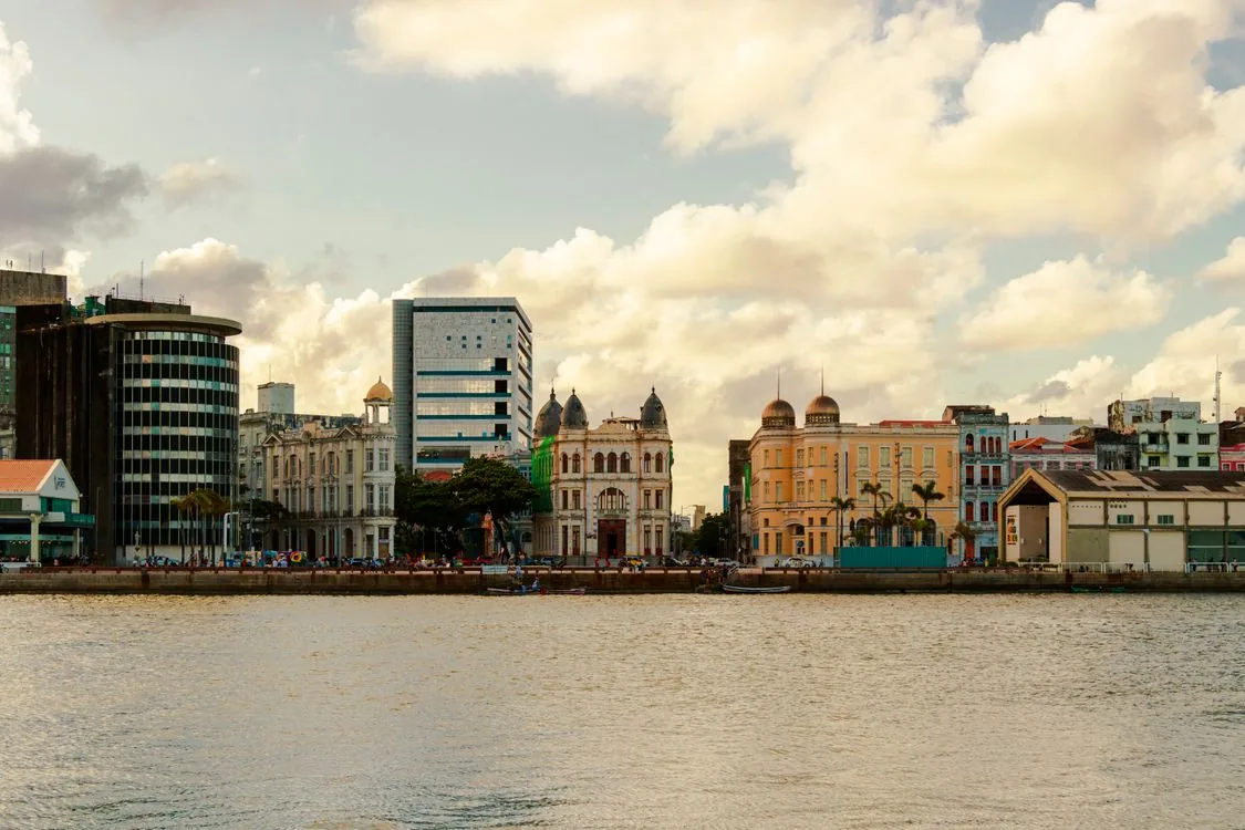 Recife city skyline viewed from the water, showing the mix of colonial and modern architecture that defines the city's urban identity along the riverfront.