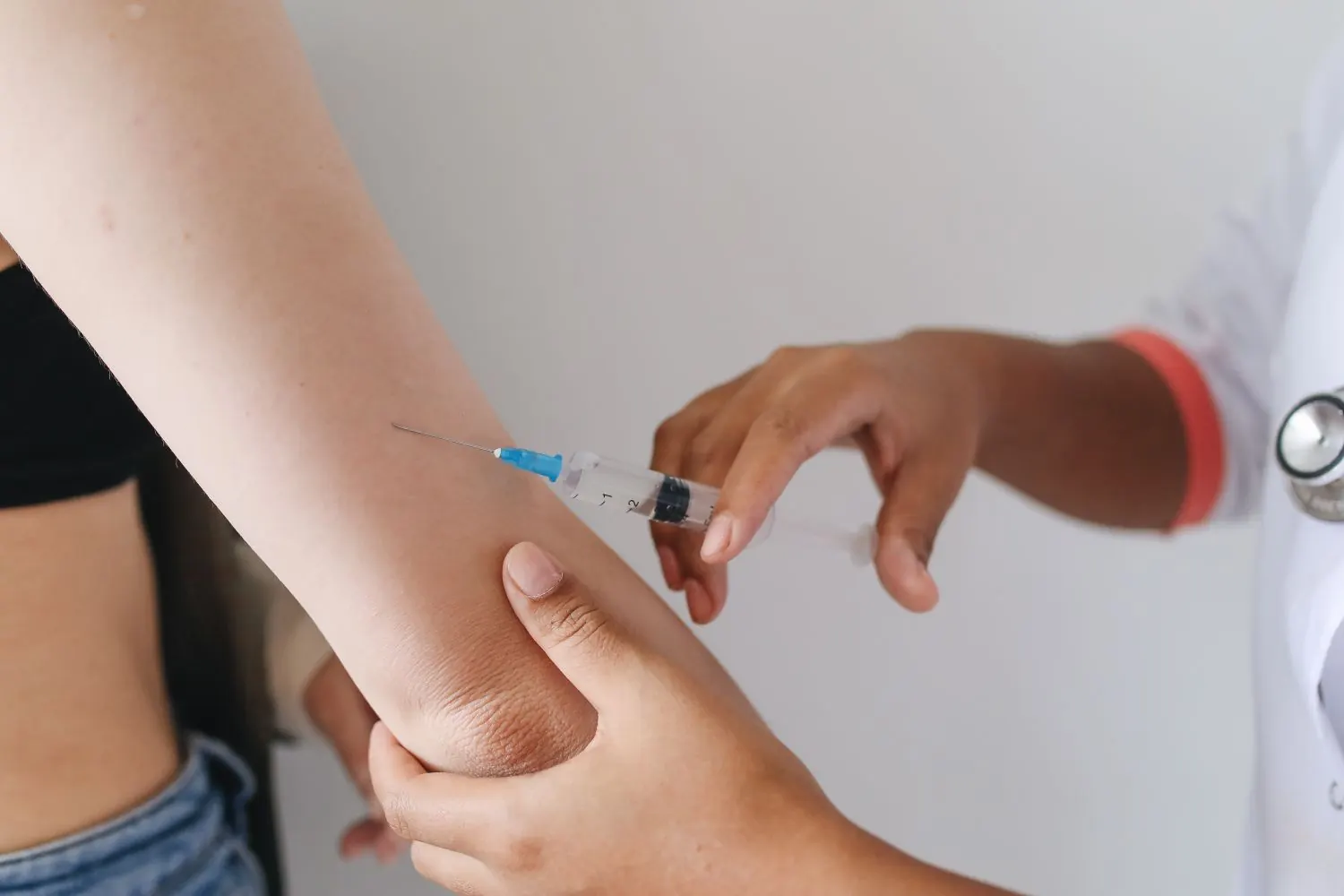 A travel vaccination being administered in a clinic, illustrating the pre-trip shots covered in this guide.